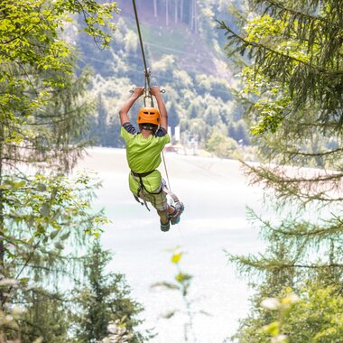 Flying-Fox-Golm in Montafon | © Golm Silvretta Lünersee Tourismus GmbH Bregenz, Stefan Kothner A boy flying over the Latschau reservoir attached to a 565 m long steel cable | © Golm Silvretta Lünersee Tourismus GmbH Bregenz, Stefan Kothner