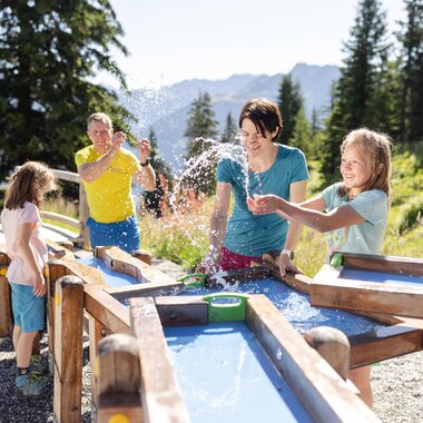 Golmis Forschungspfad at Erlebnisberg Golm | © Golm Silvretta Lünersee Tourismus GmbH Bregenz, Stefan Kothner Father and mother discovering the power of water together with their two daughters while playing water games on Golmis Forschungspfad | © Golm Silvretta Lünersee Tourismus GmbH Bregenz, Stefan Kothner